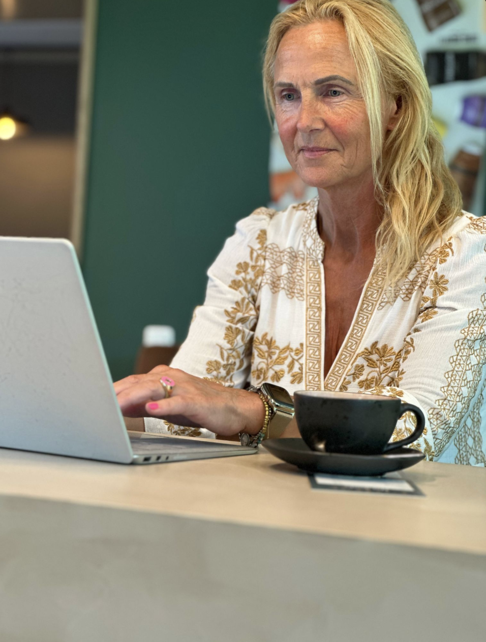 Klazina Jellema werkt achter haar laptop met een kop koffie